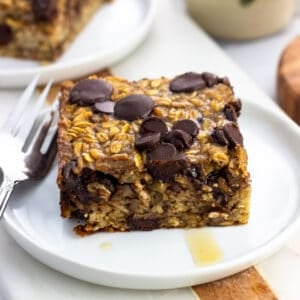 A square of chocolate chip baked oatmeal served with maple syrup.