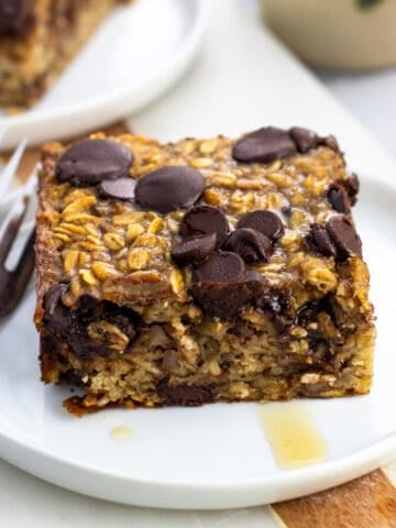 A square of chocolate chip baked oatmeal served with maple syrup.