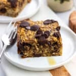 Maple syrup drizzled baked oatmeal and a fork on a plate.