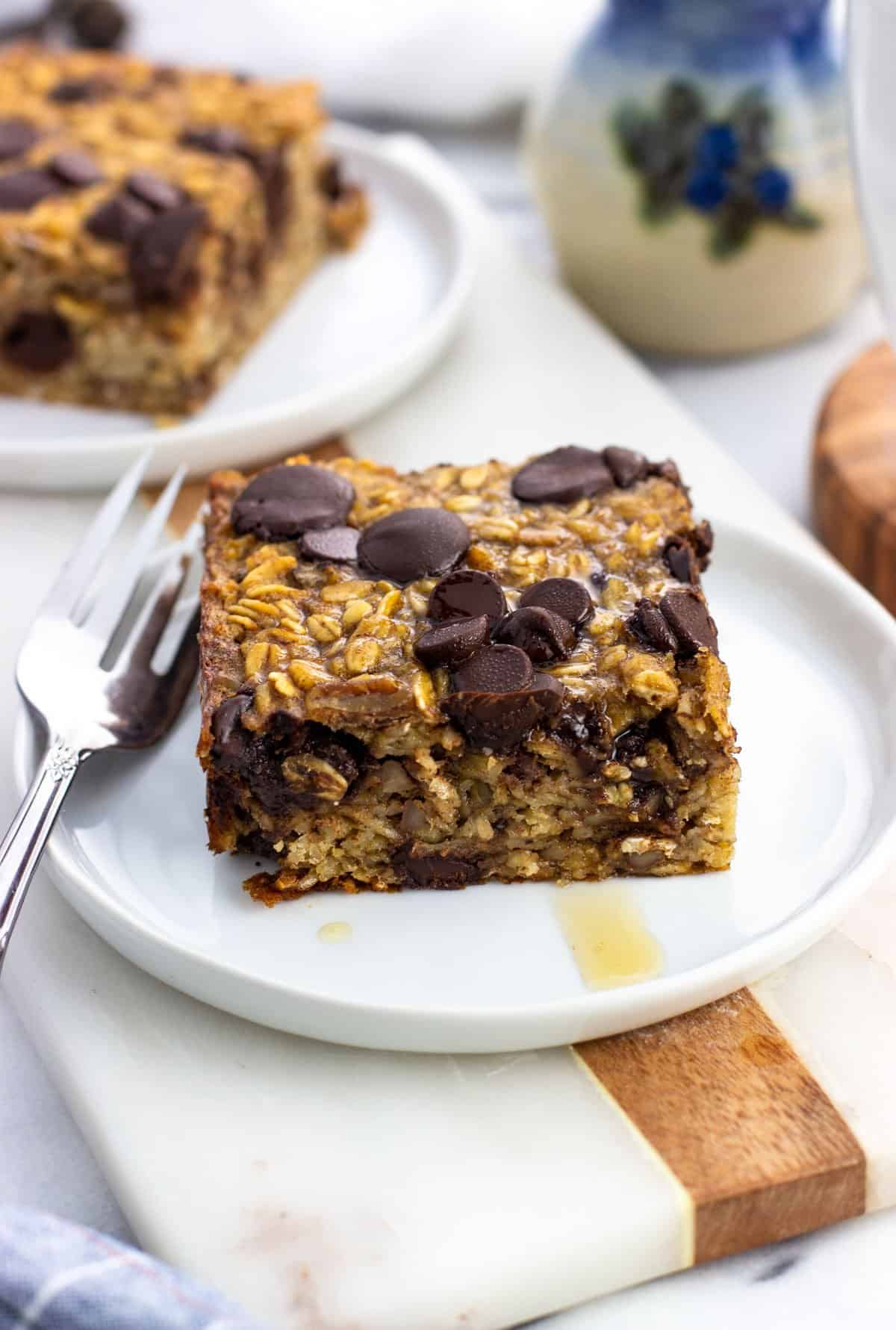 Maple syrup drizzled baked oatmeal and a fork on a plate.