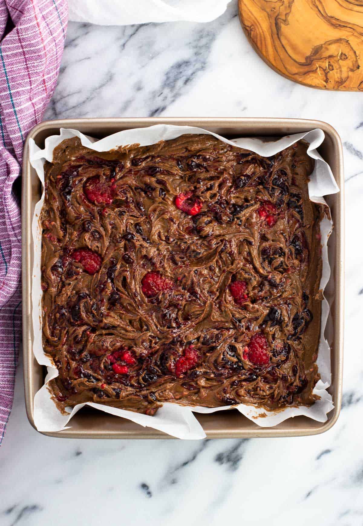 Raspberry jam swirled into a pan of brownies before baking.