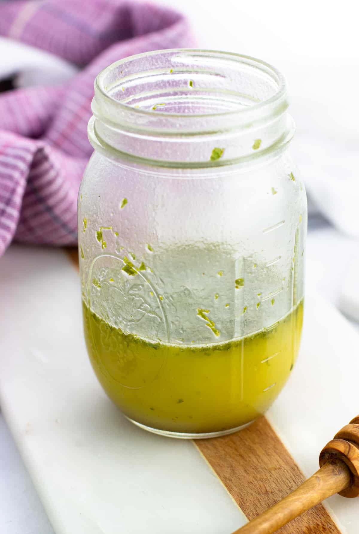 Honey mint vinaigrette combined in a glass jar.