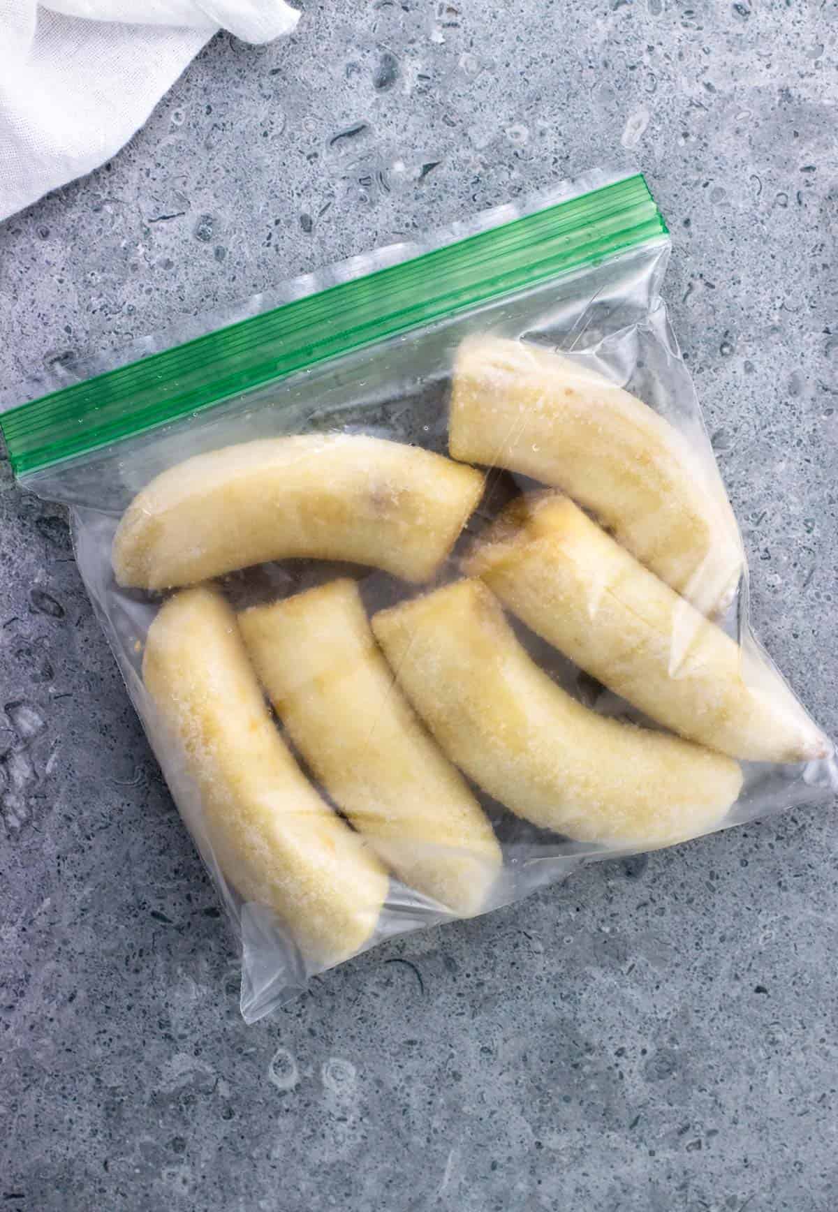 Six fully frozen banana halves sealed in a plastic bag.