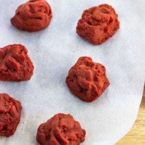 Tablespoon-size blobs of tomato paste on parchment paper.
