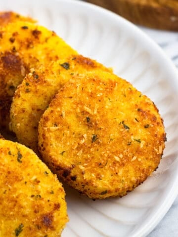 Pan-fried slices of polenta arranged on a serving plate.