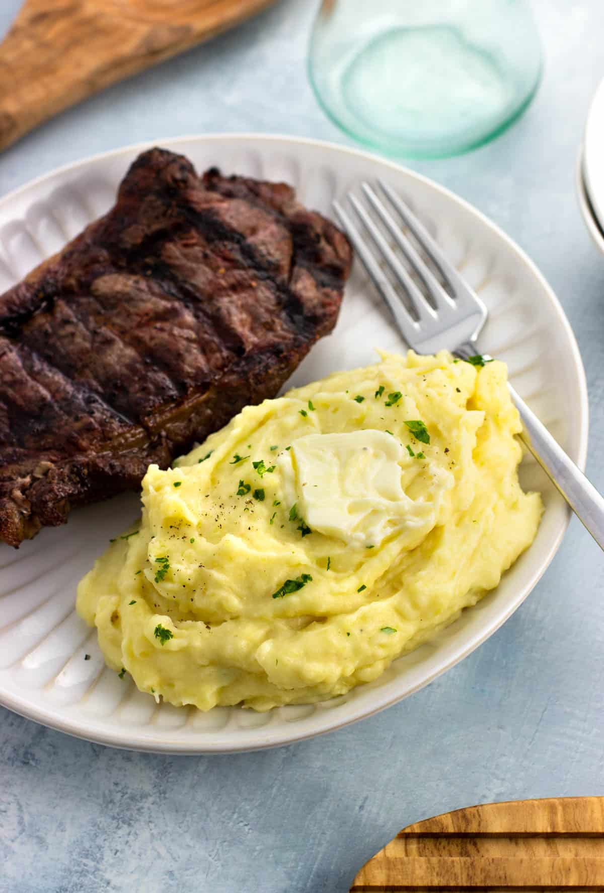 A plate with a grilled steak and side of roasted garlic mashed potatoes.