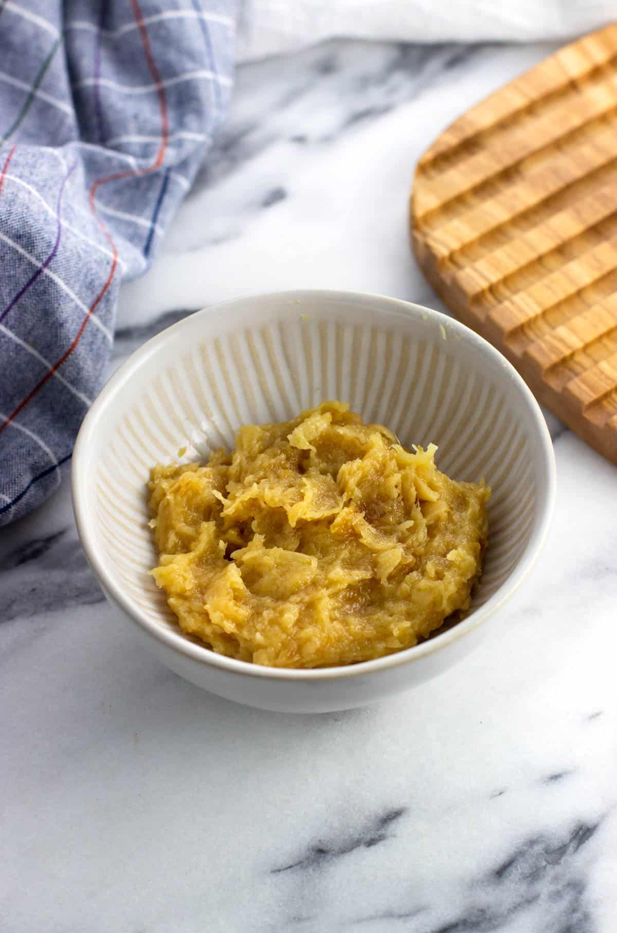 Mashed roasted garlic cloves in a small bowl.