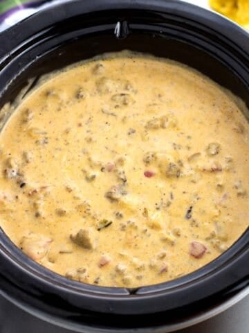 A small round crock pot full of beef queso.