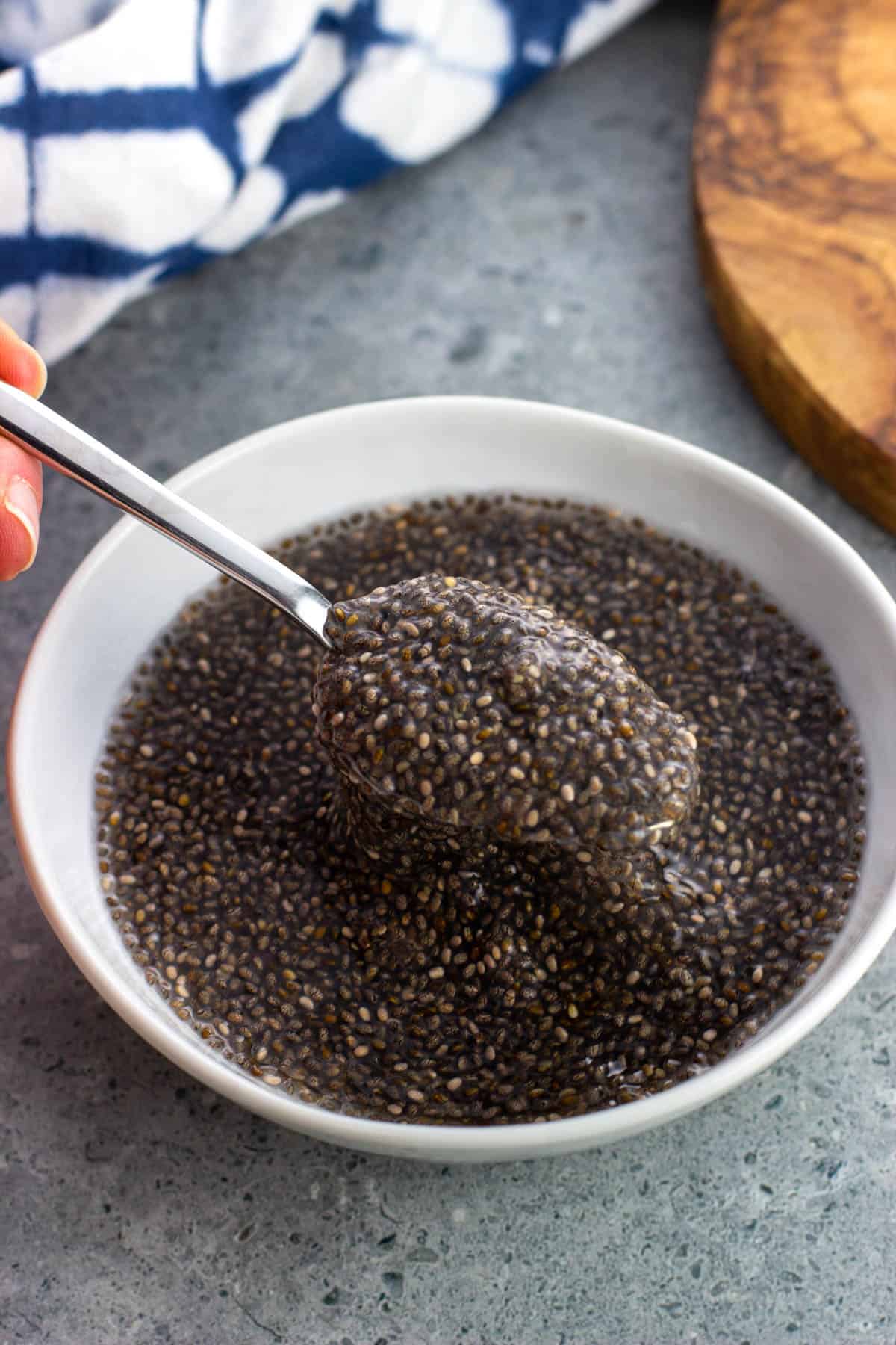 Soaked gelatinous chia seeds in a bowl with a spoon lifting out some.