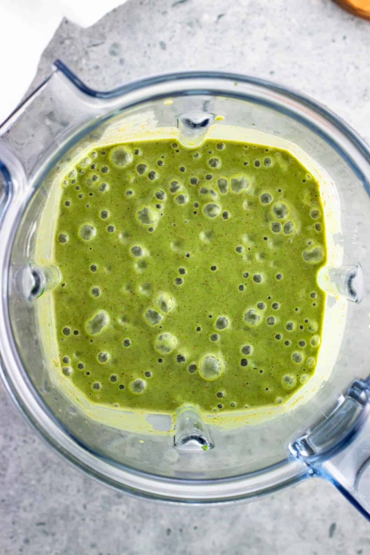 Fully blended green smoothie in a blender.