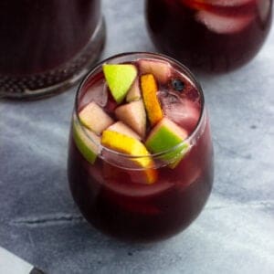 A glass of non-alcoholic sangria filled with fruit.