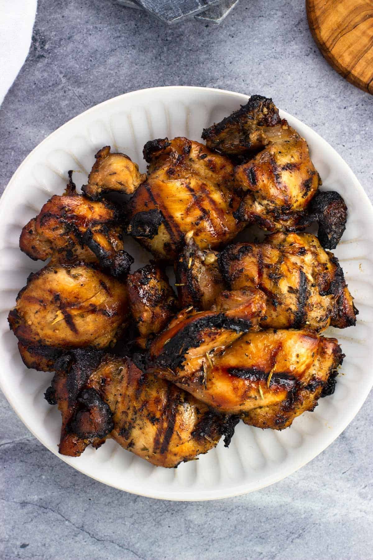 Two pounds of grilled chicken thighs on a serving plate.