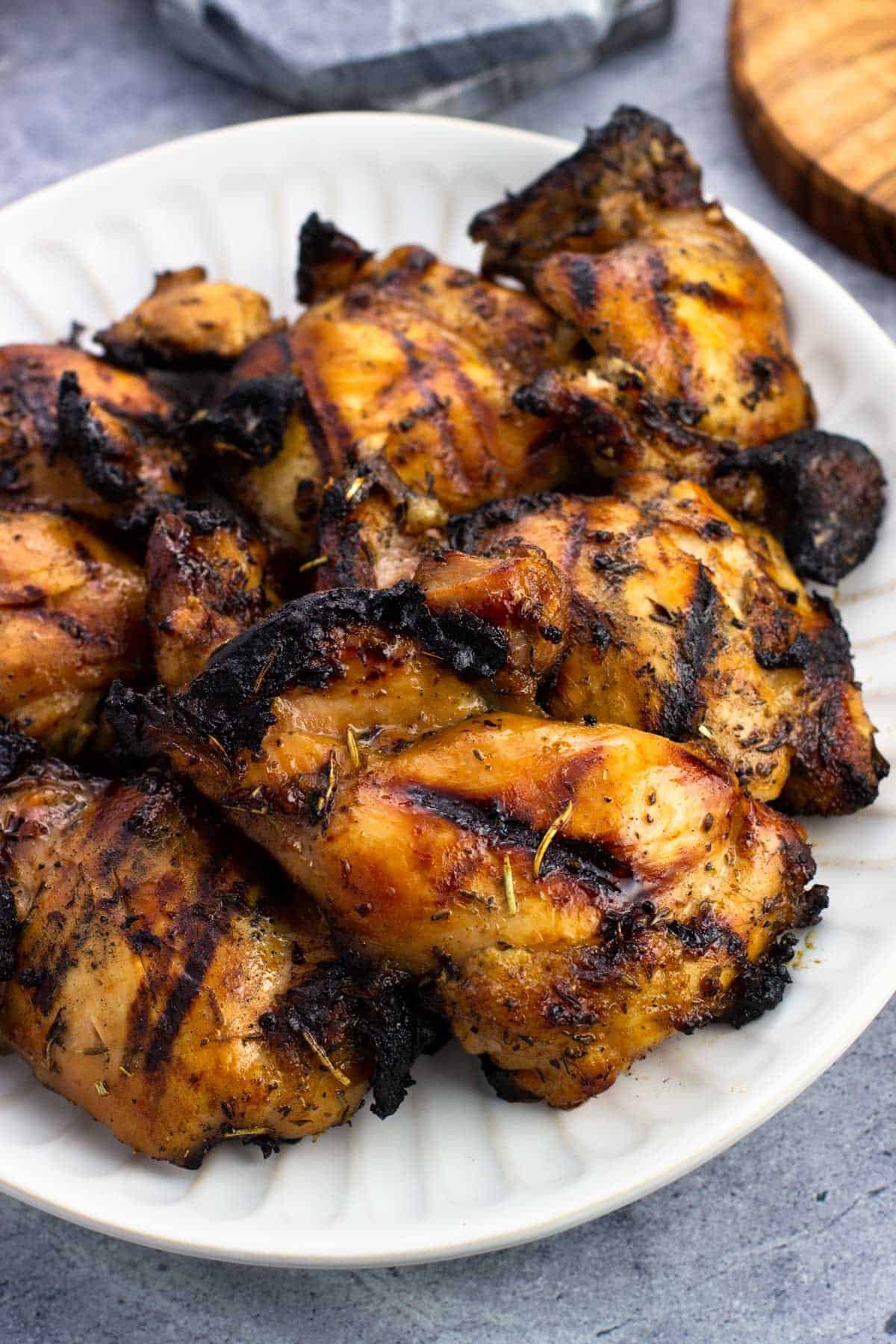 Marinated and grilled boneless skinless chicken thighs on a plate.