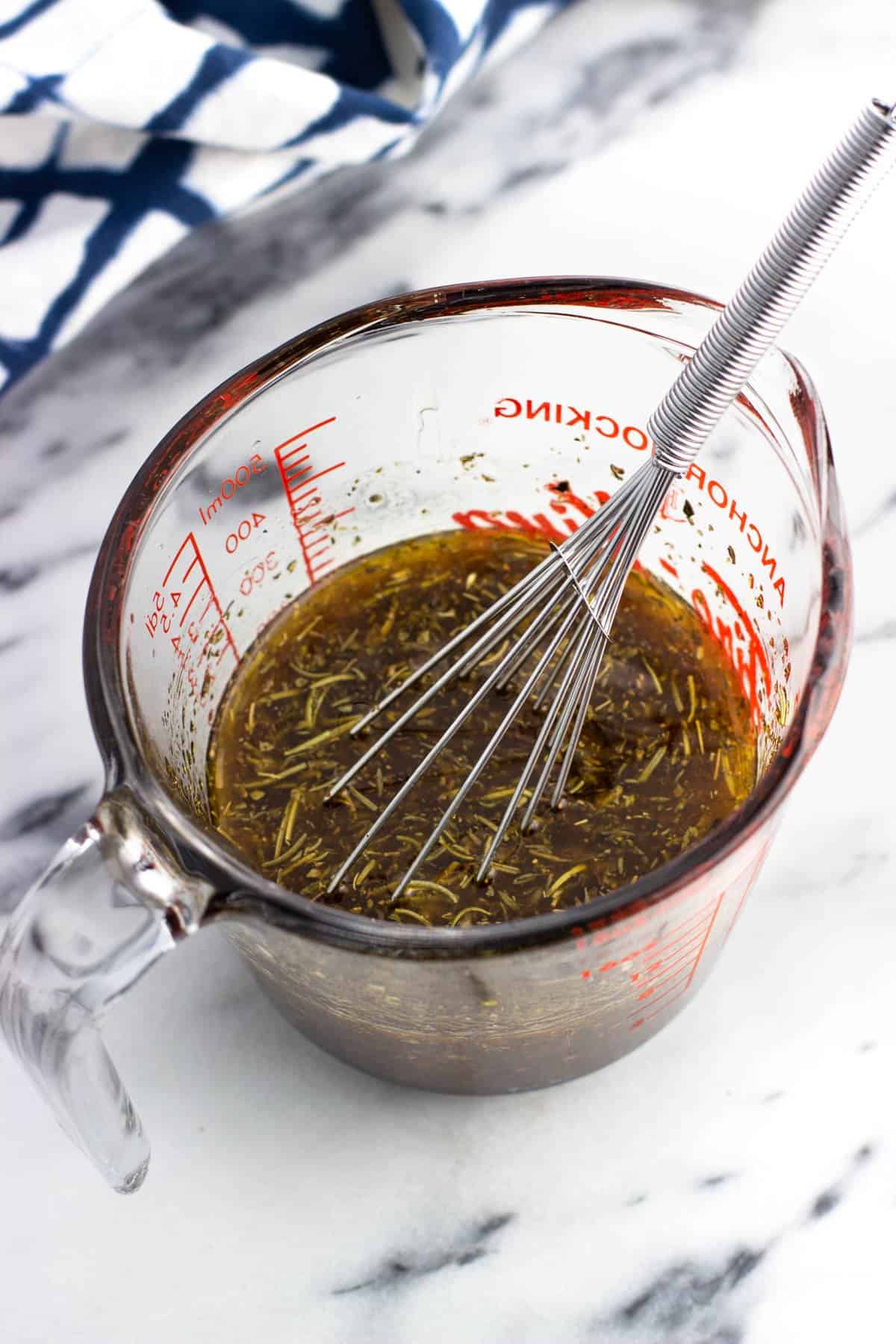 Chicken thigh marinade ingredients whisked together in a glass measuring cup.