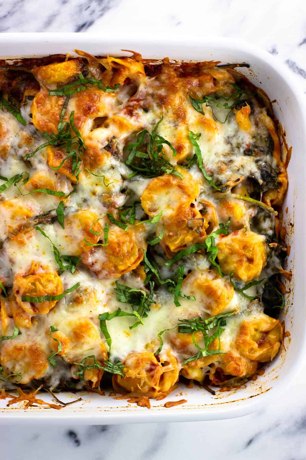 Baked tortellini in a large rectangular baking dish.