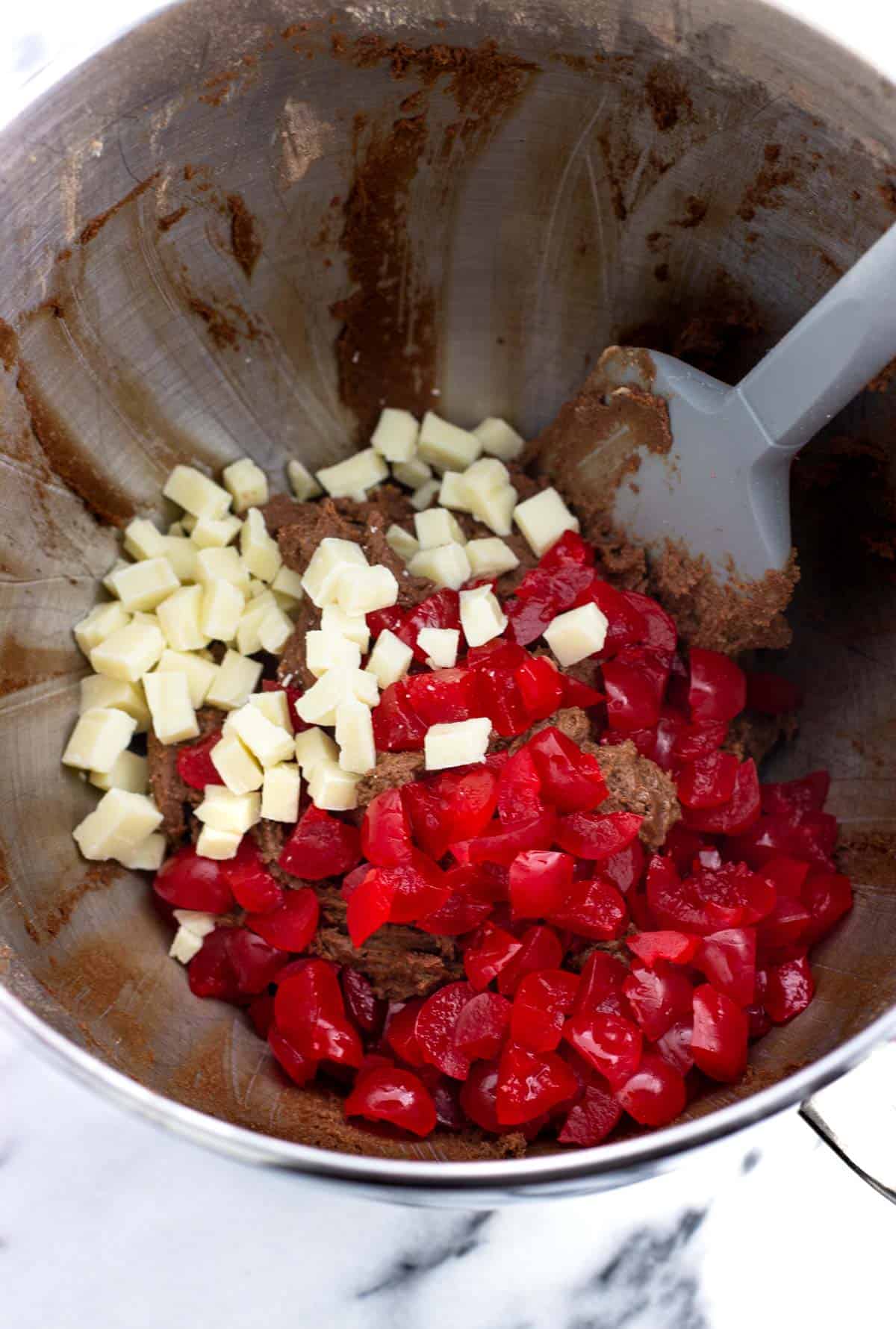 White chocolate and maraschino cherries added to the bowl of cookie dough.