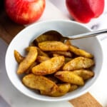 A small bowl of air fryer apples with a spoon.