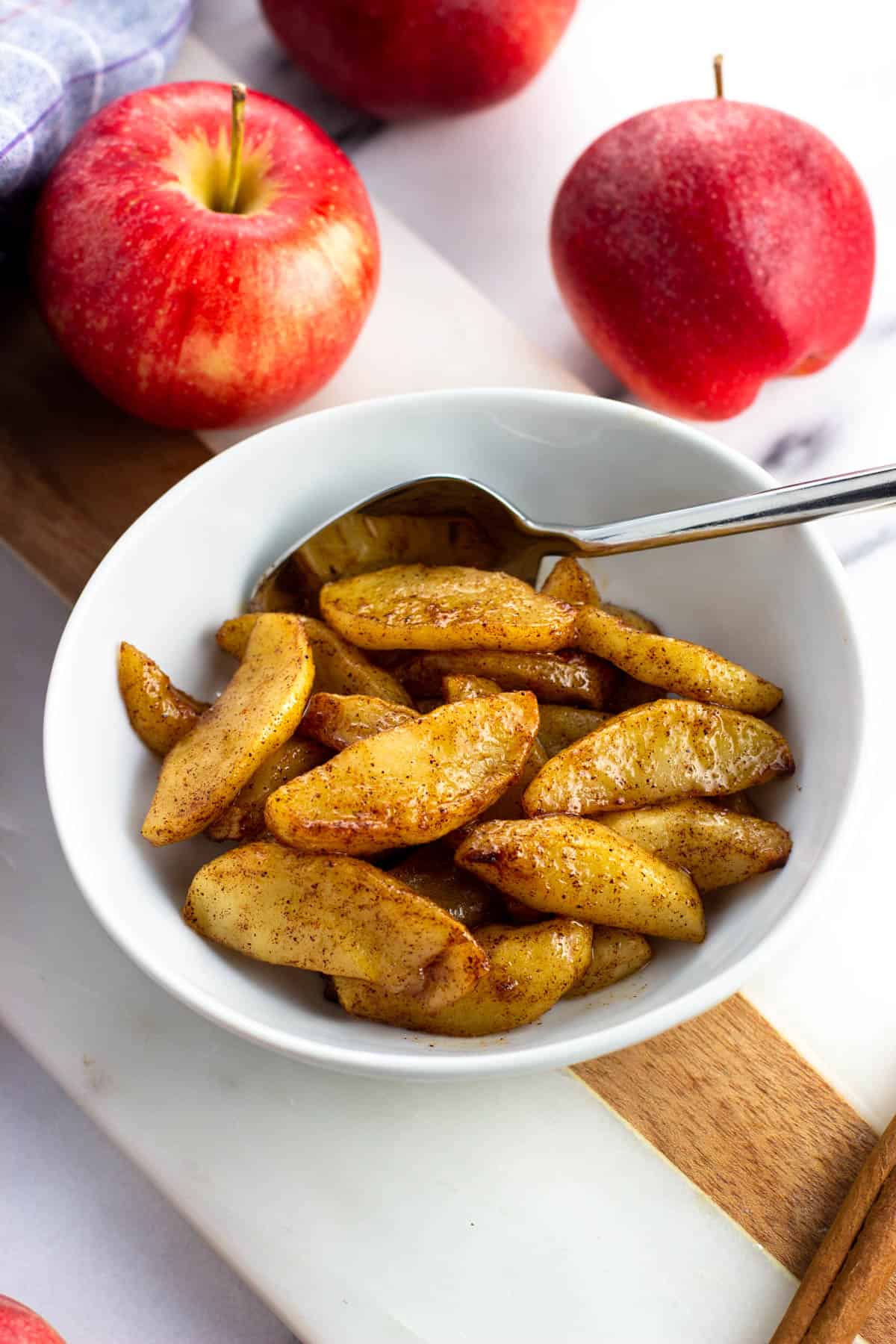 A small bowl of air fryer apples with a spoon.