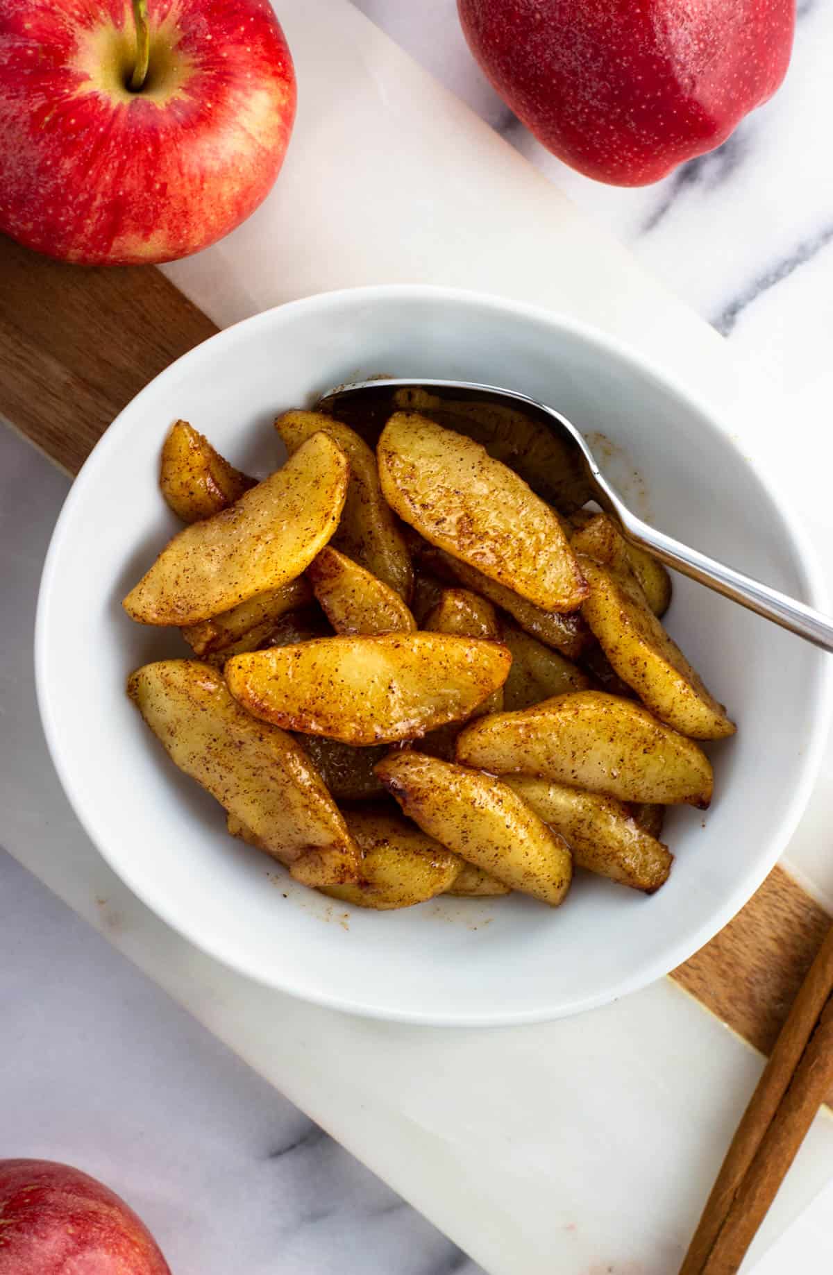 A small bowl of air fryer apples with a spoon.