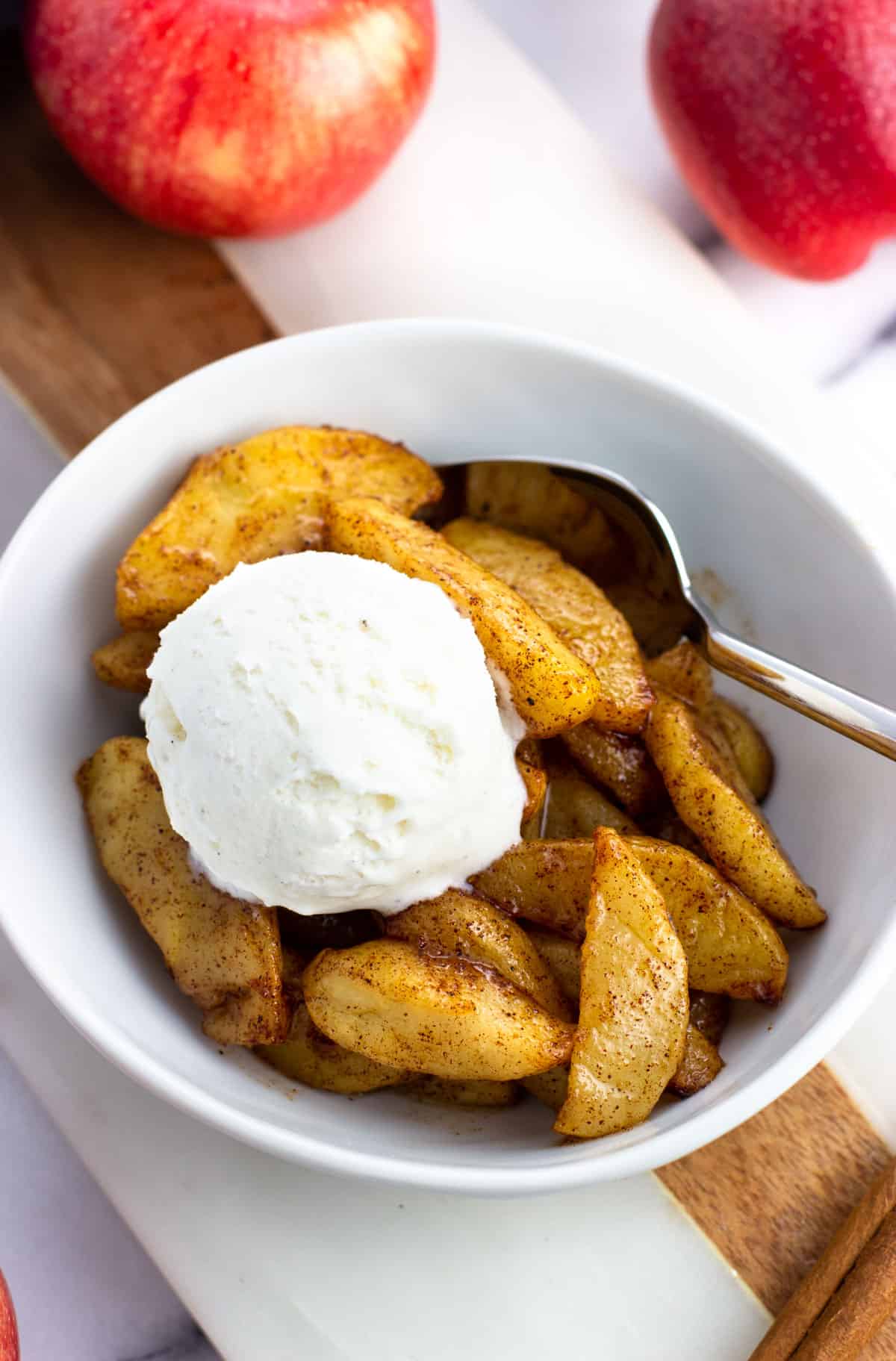 A serving of air fried apples topped with a scoop of vanilla ice cream.