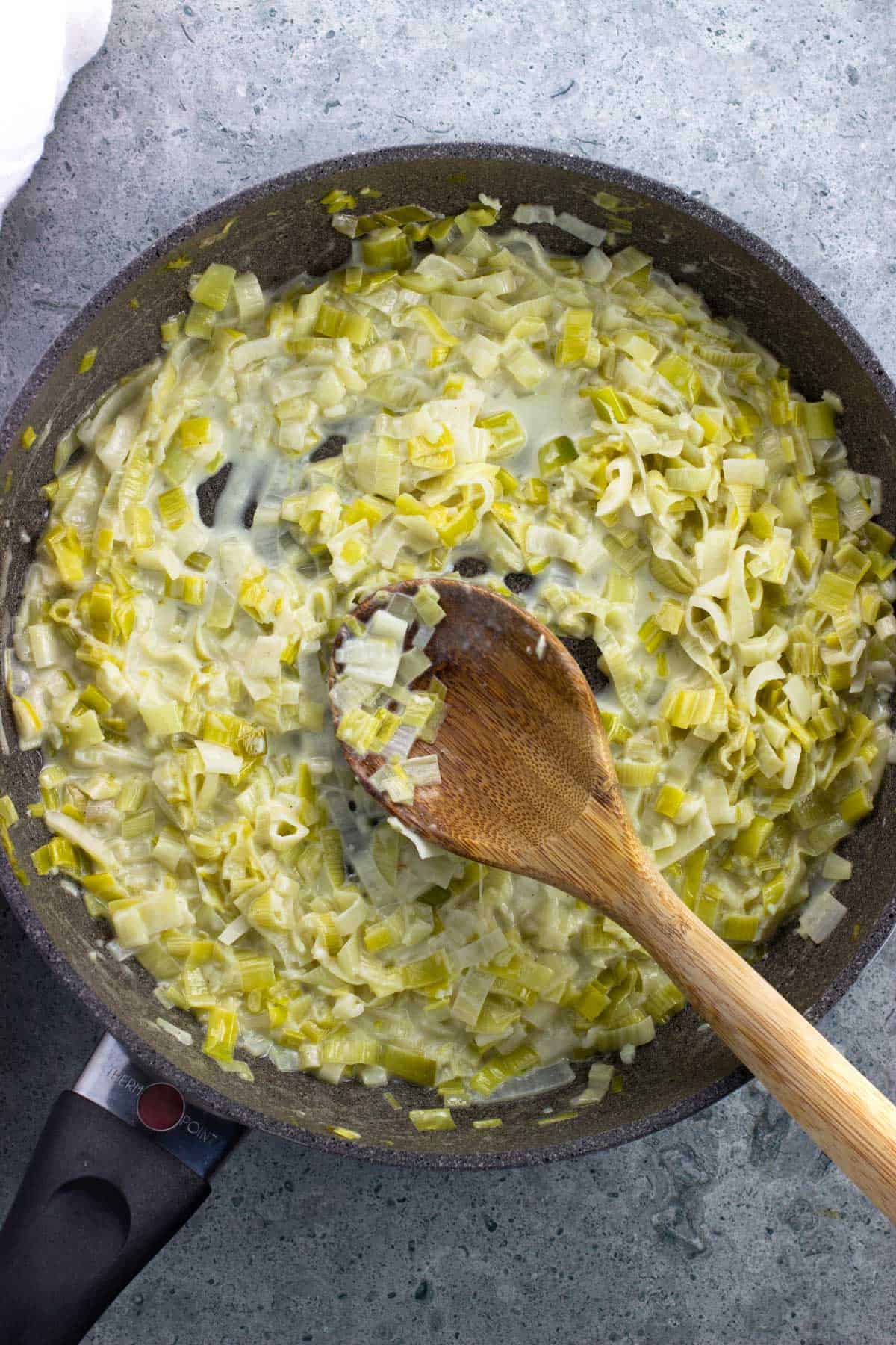 Cream added to the pan of leeks to thicken.