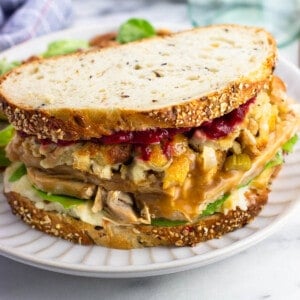 A loaded homemade Gobbler sandwich on a plate showing all of the layers.
