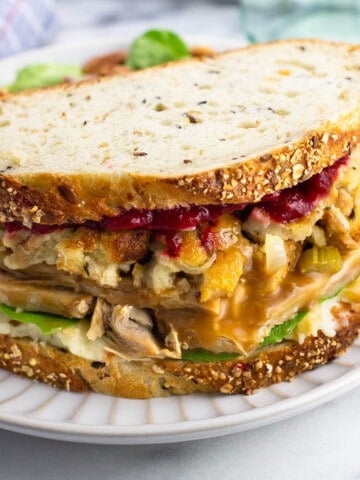A loaded homemade Gobbler sandwich on a plate showing all of the layers.