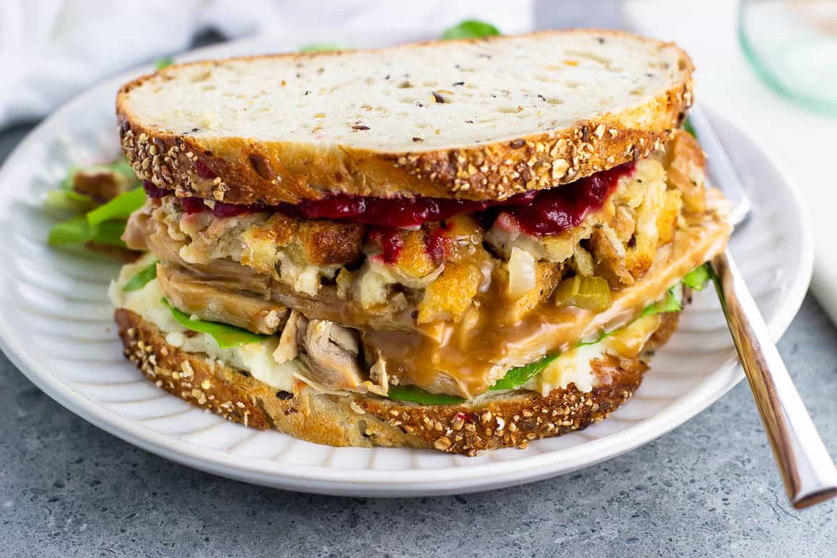 A loaded homemade Gobbler sandwich on a plate showing all of the layers.