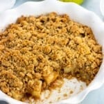 A serving dish of pear crumble with a big scoop removed.