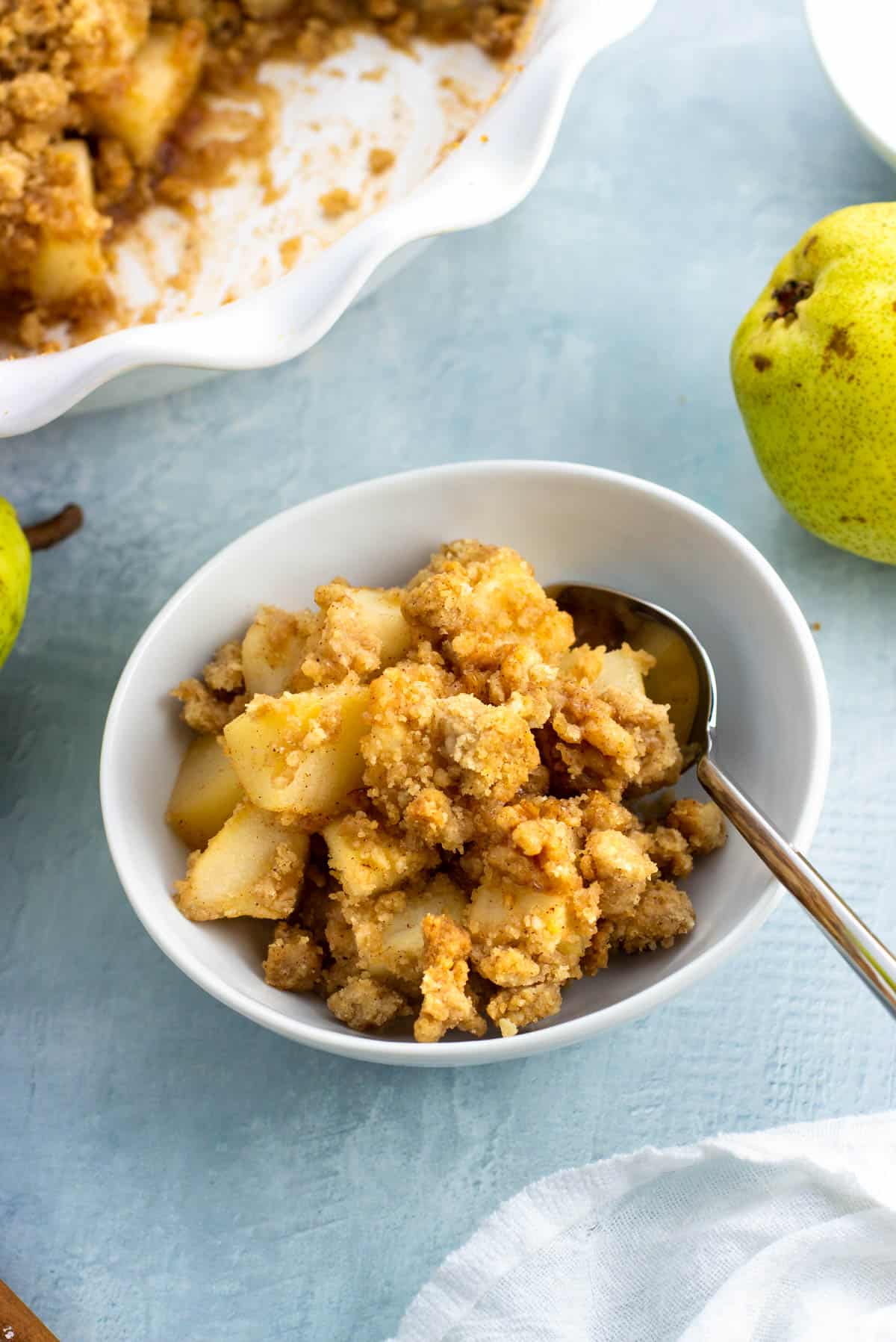 A small bowl of crumble with a spoon in it.