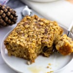 A square of eggnog oatmeal on a small plate with a bite removed.