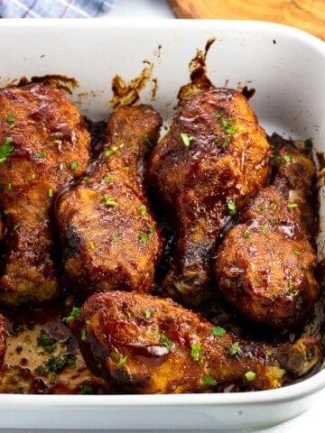 BBQ sauce coated chicken drumsticks in a baking dish ready to serve.