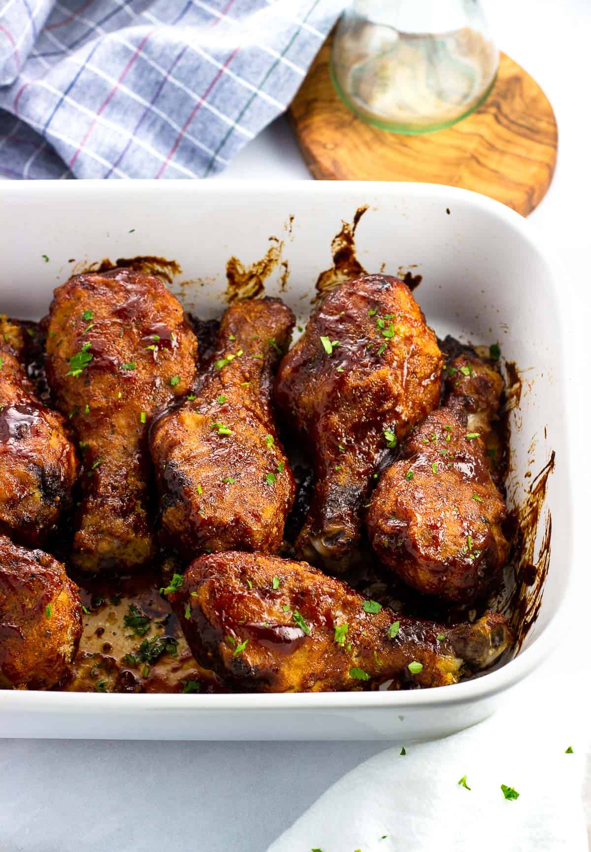BBQ coated chicken drumsticks in a large rectangular baking dish.