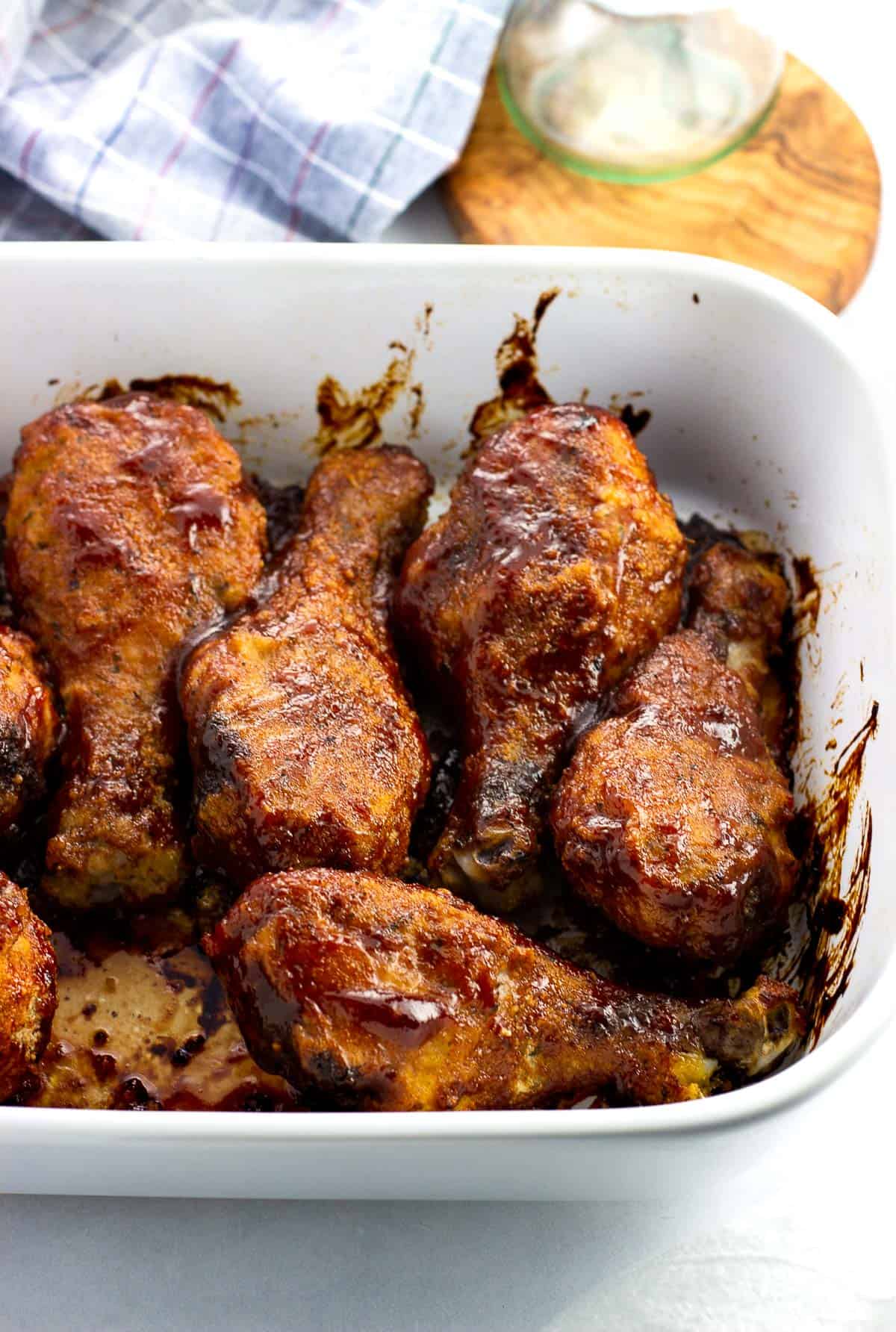 BBQ chicken drumsticks in a rectangular pan after being baked.