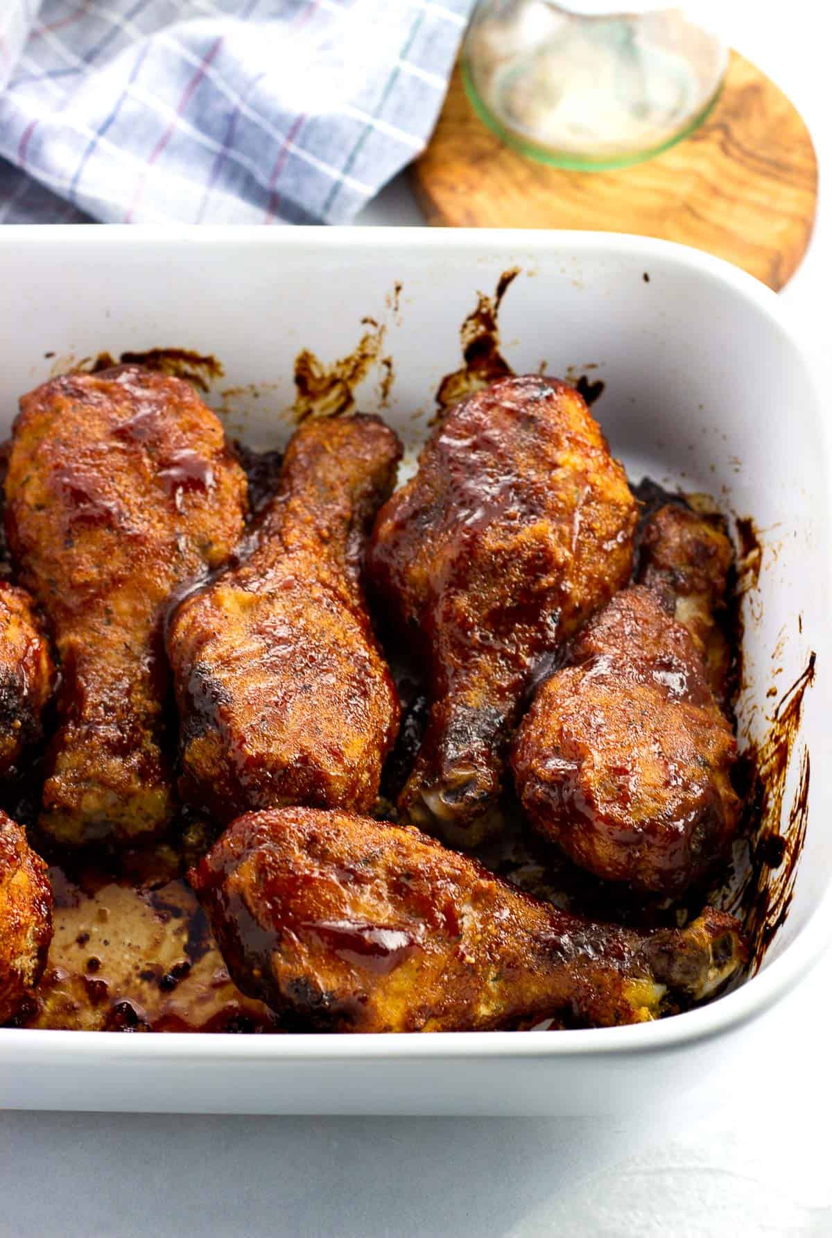 BBQ chicken drumsticks in a rectangular pan after being baked.