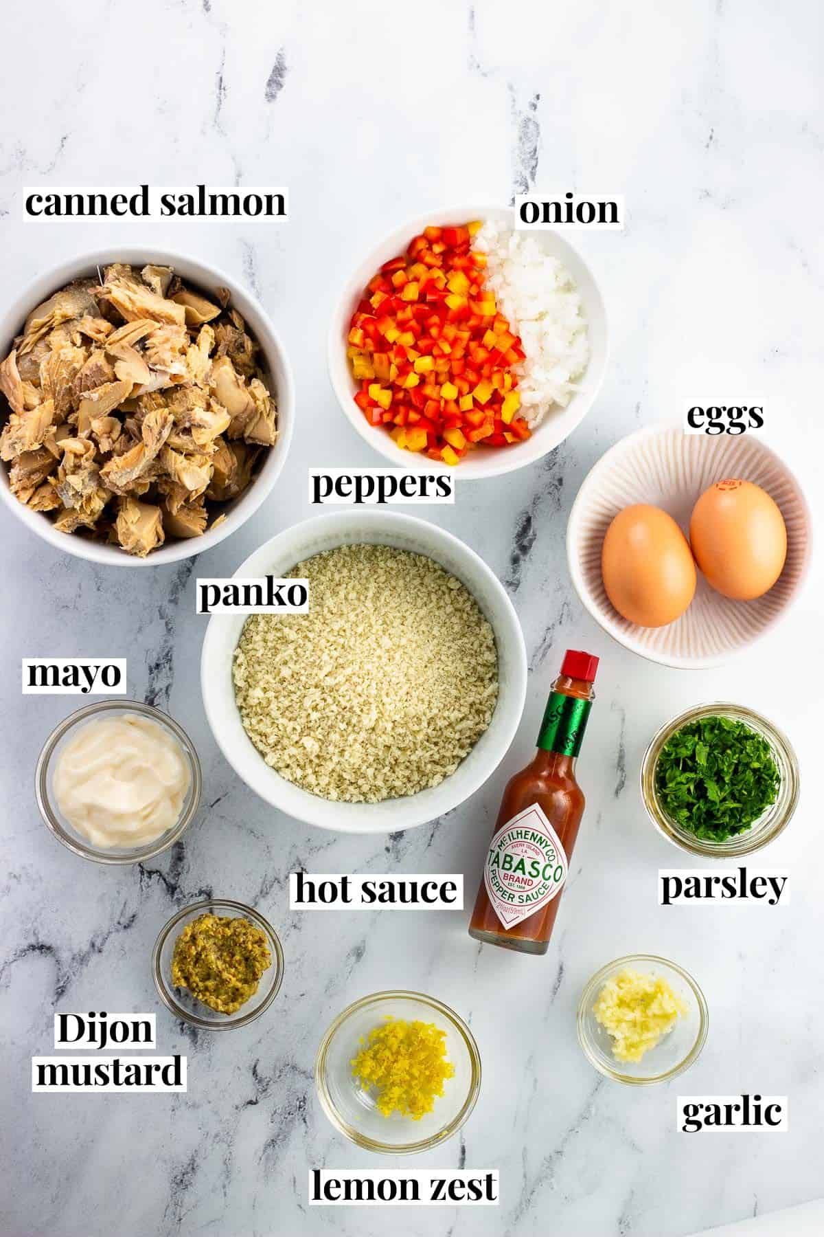 Baked salmon patty ingredients in separate bowls labeled with their names.