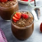 Chocolate chia seed pudding cups topped with strawberries and raspberries.