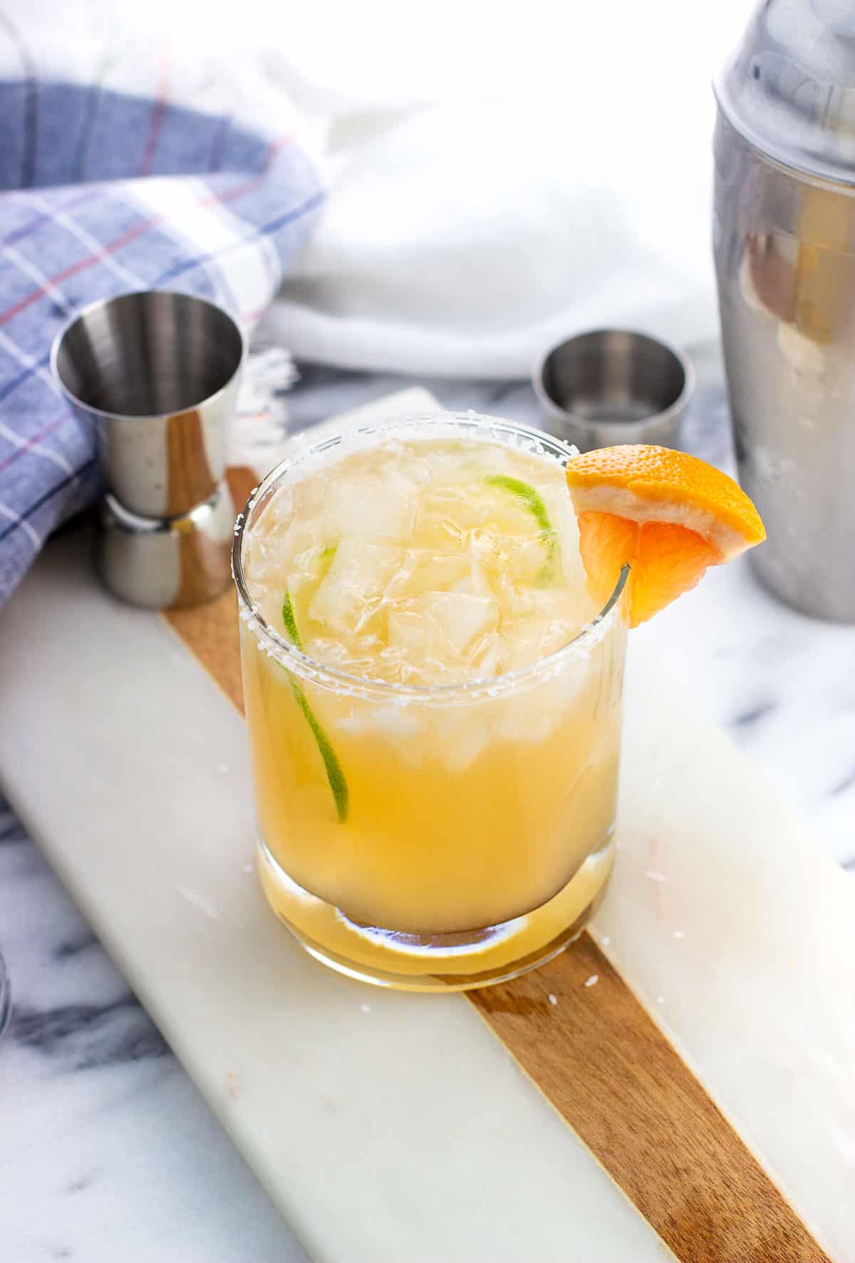 A paloma mocktail with a salted rim and grapefruit wedge garnish.