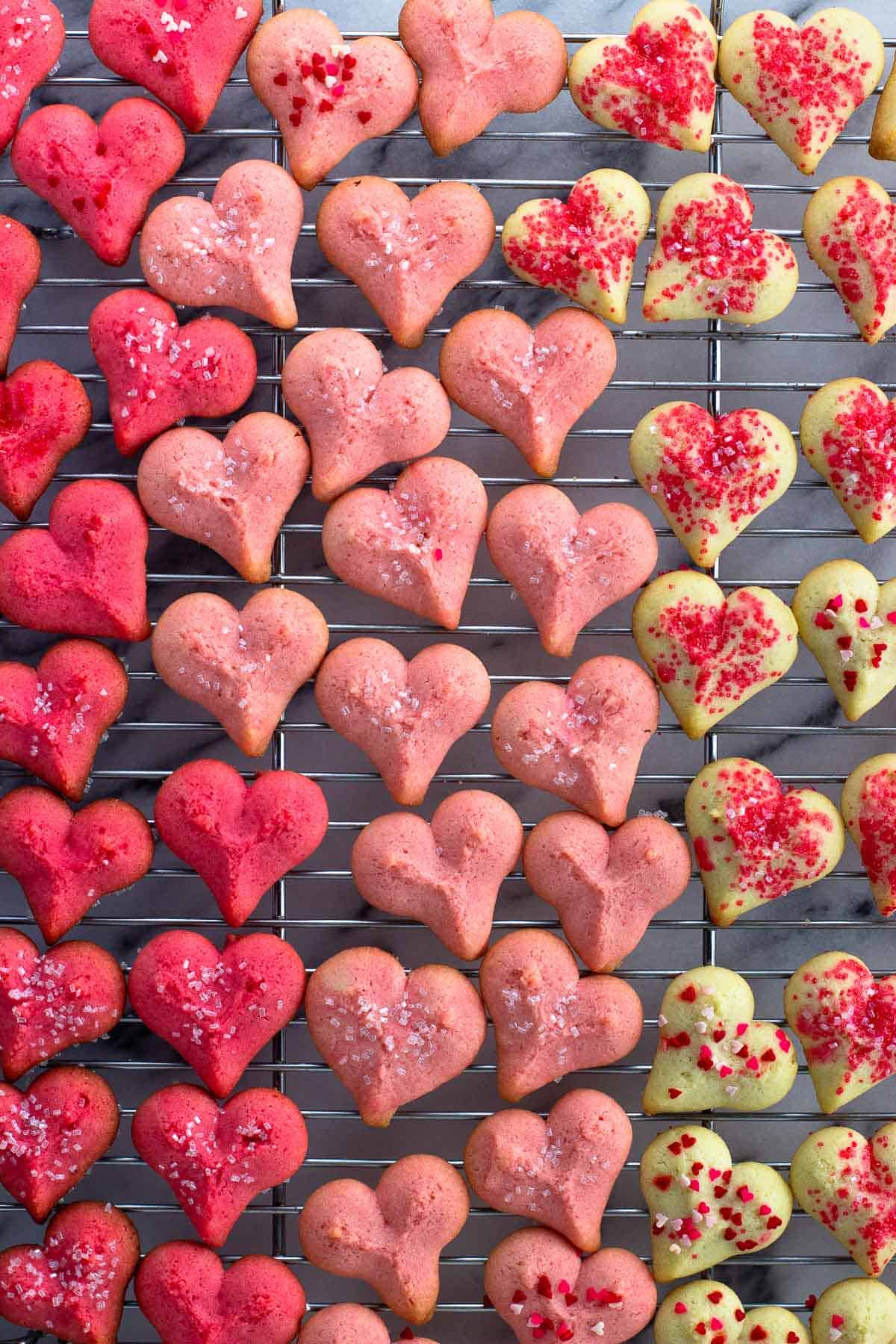 Pink ombre heart cookies on a wire rack.
