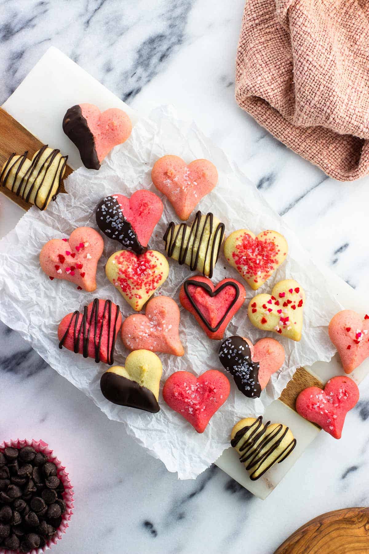 Valentine's Day spritz cookies on a sheet of crinkled parchment paper.