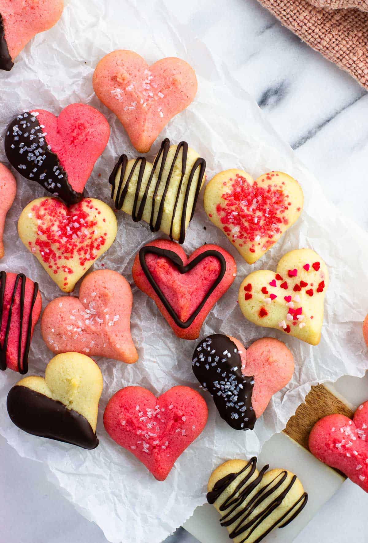 An assortment of white and pink decorated heart cookies.