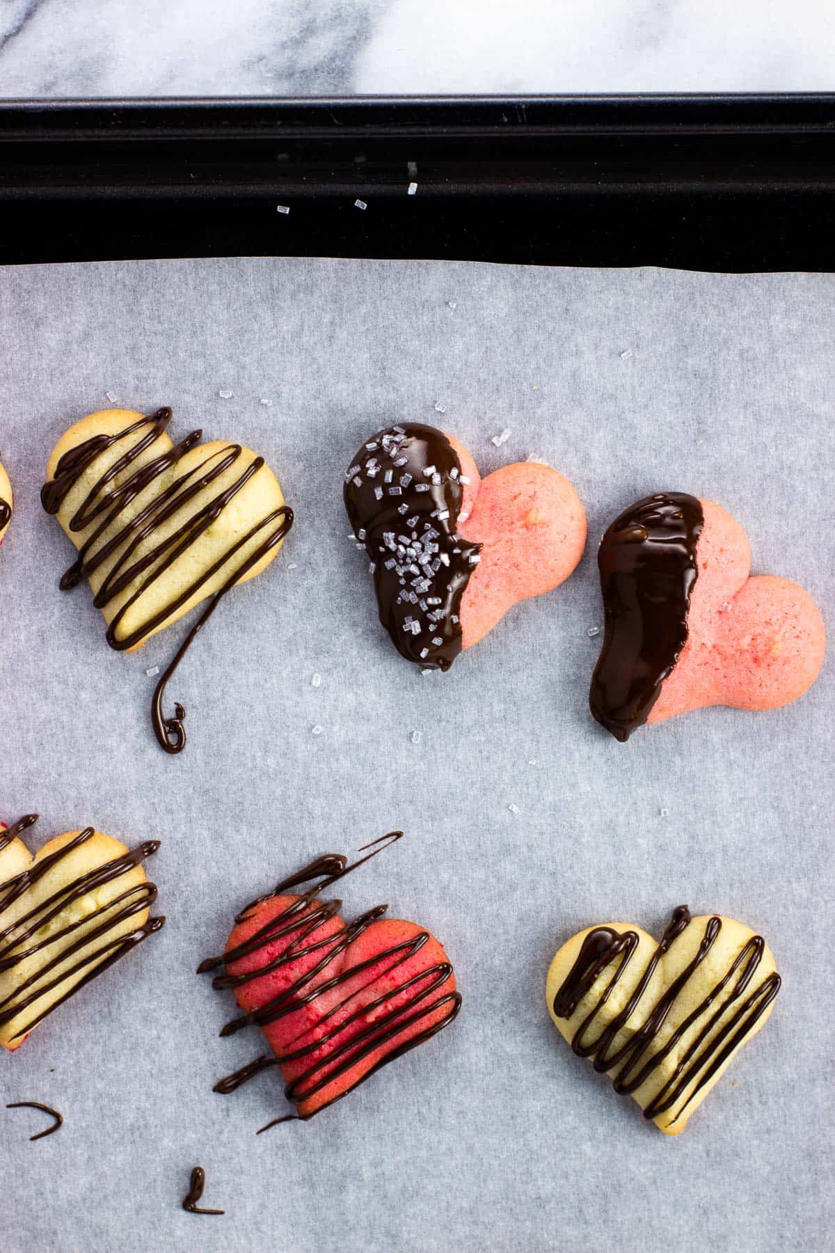 Heart spritz cookies decorated in melted chocolate.