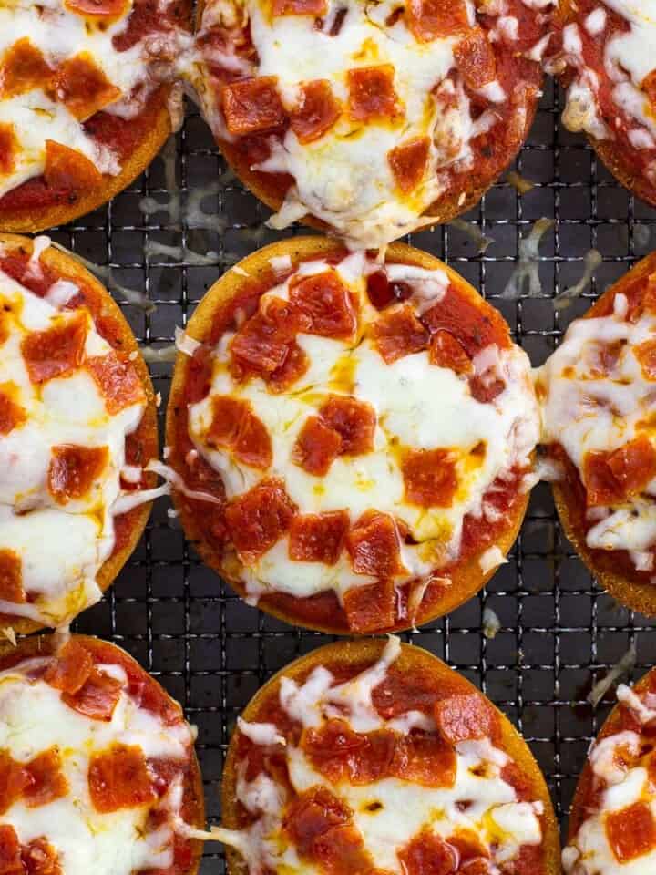 Mini pepperoni pizza bagels cooked on an air fryer basket.