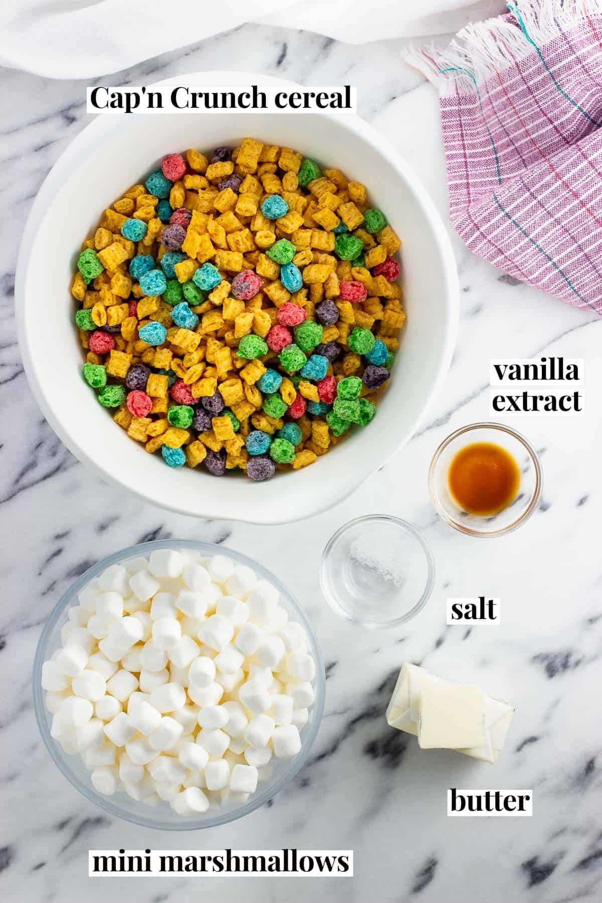 Labeled recipe ingredients in separate bowls: Cap'n Crunch cereal, vanilla extract, mini marshmallows, salt, and butter.