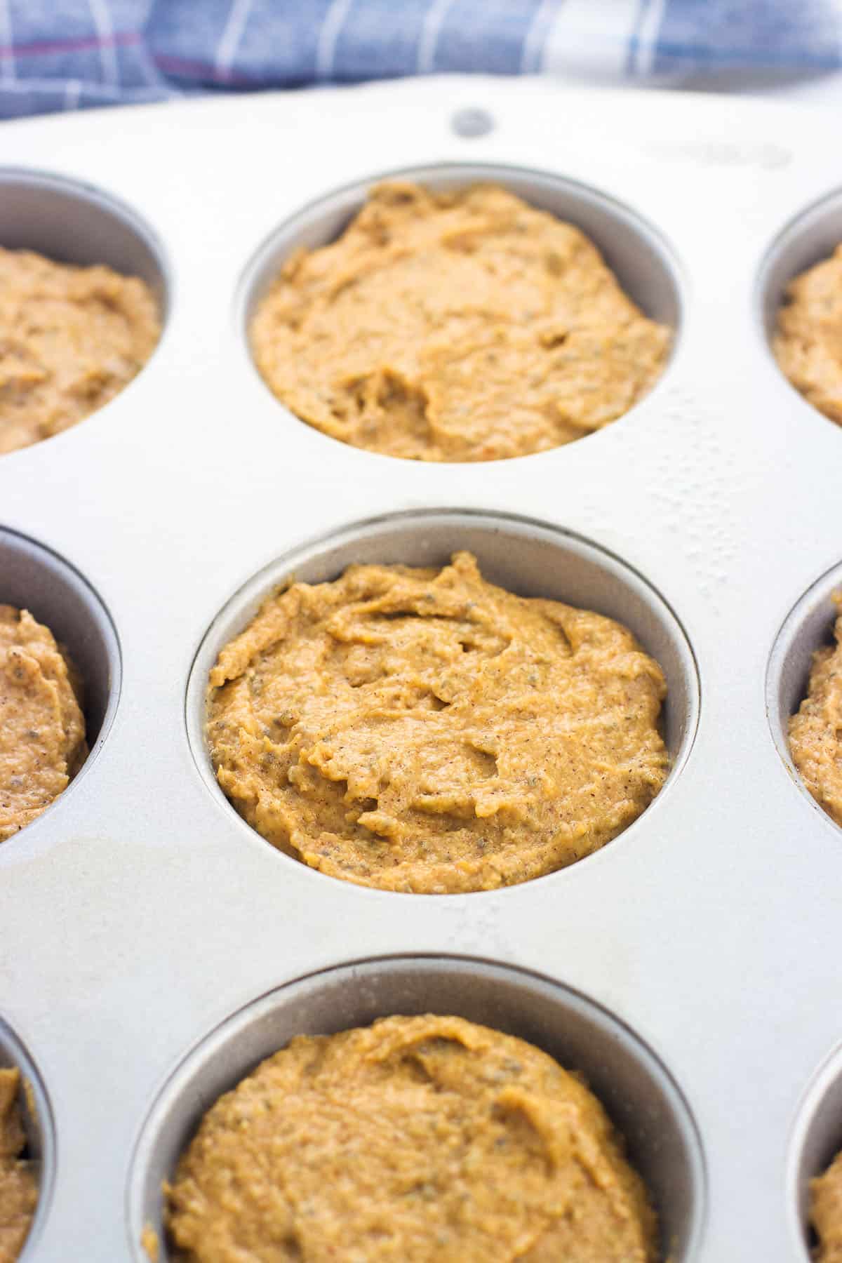 Batter portioned out into a metal muffin pan.