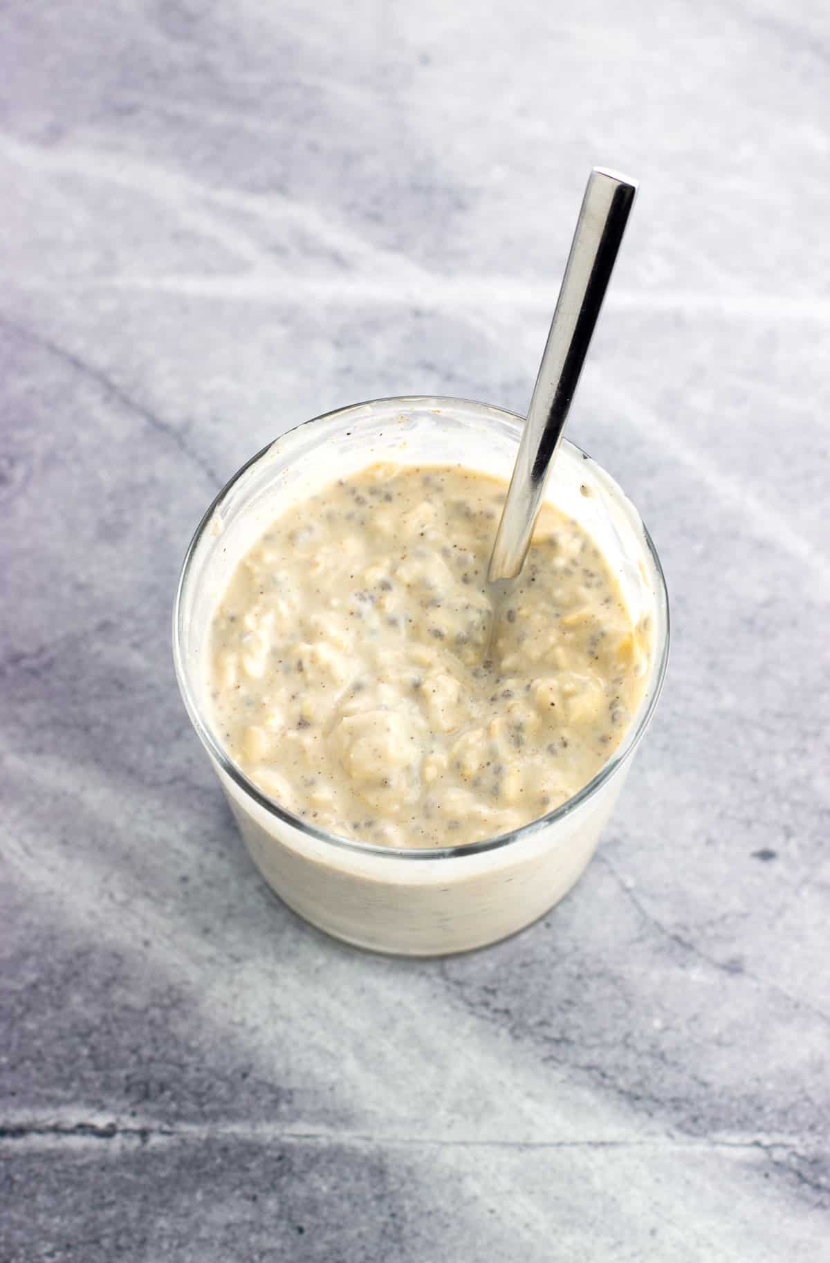 Thick and creamy overnight oats in a glass after being in the fridge overnight.