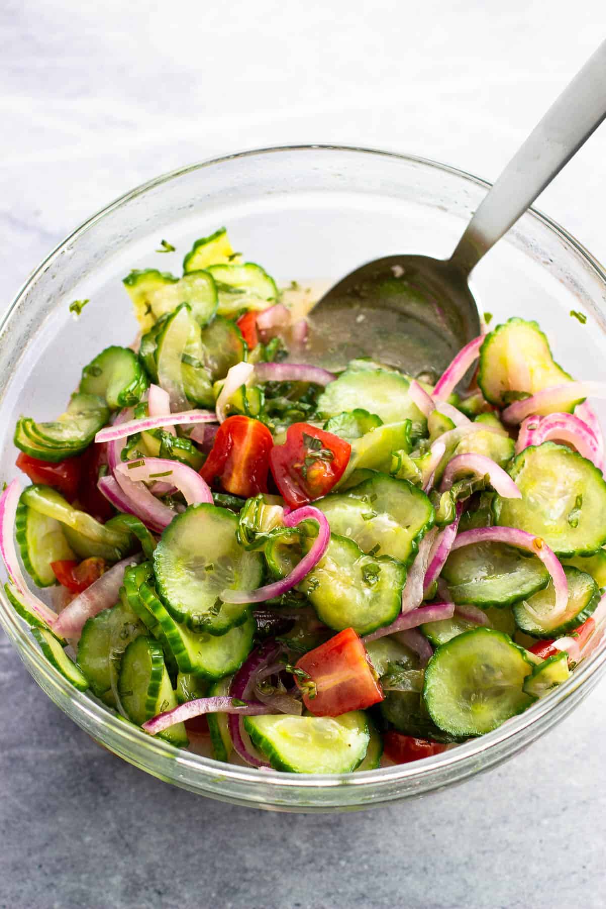 Cucumber, tomato, and red onion salad in a bowl ready to serve.