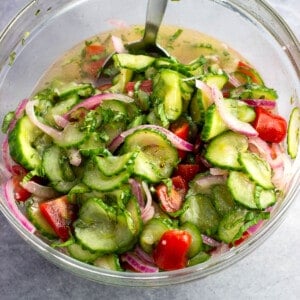Marinated Cucumber, tomato, and red onion salad in a bowl ready to serve.