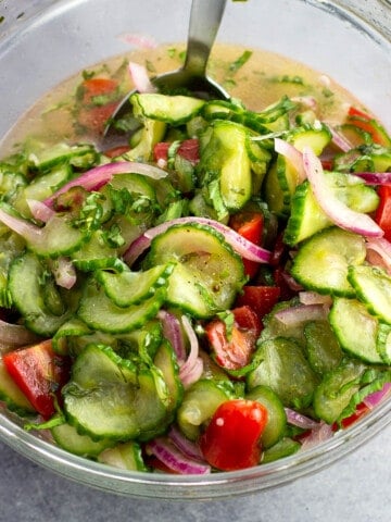 Marinated Cucumber, tomato, and red onion salad in a bowl ready to serve.