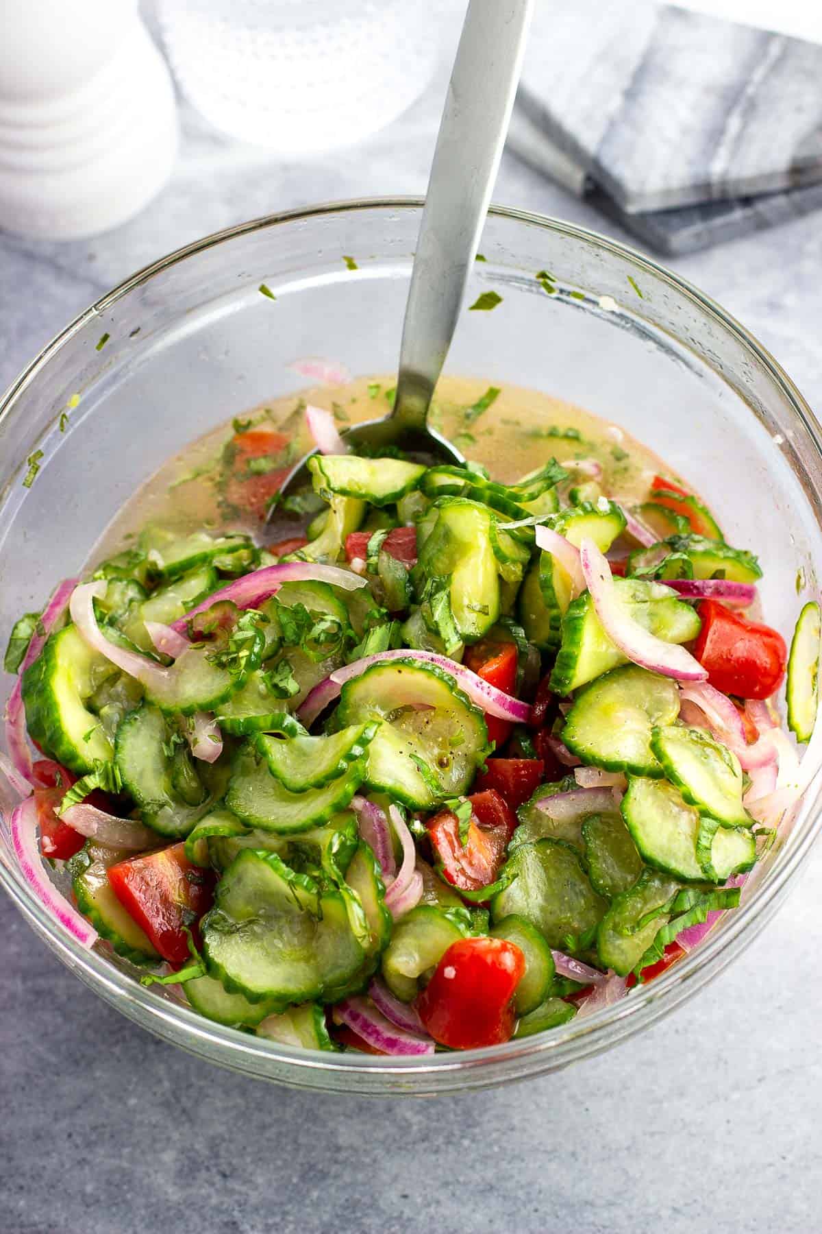 Cucumber, tomato, and red onion salad in a bowl ready to serve.